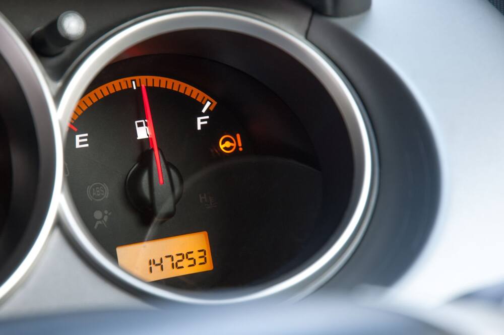 Compteur d’une voiture : jauge de carburant et 147 253 km affichés